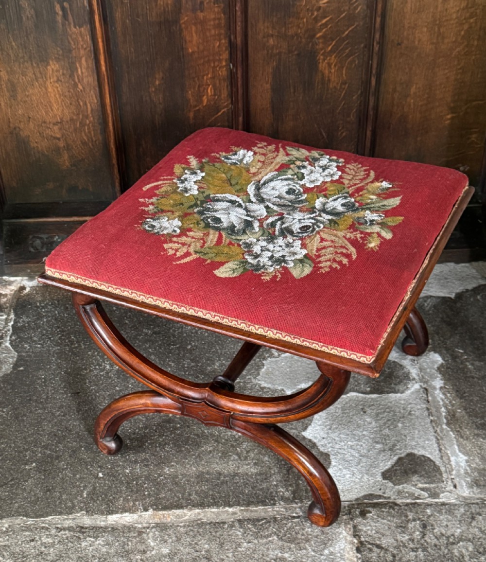 A Victorian walnut stool featuring curved X-frame legs, a turned central stretcher, and a red textile seat embellished with floral glass beadwork. View V