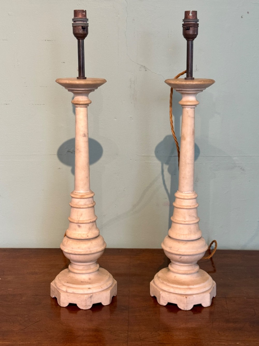 A pair of turned off-white marble table lamps featuring cylindrical baluster shafts, stepped circular bases, and cream pleated fabric shades. View III