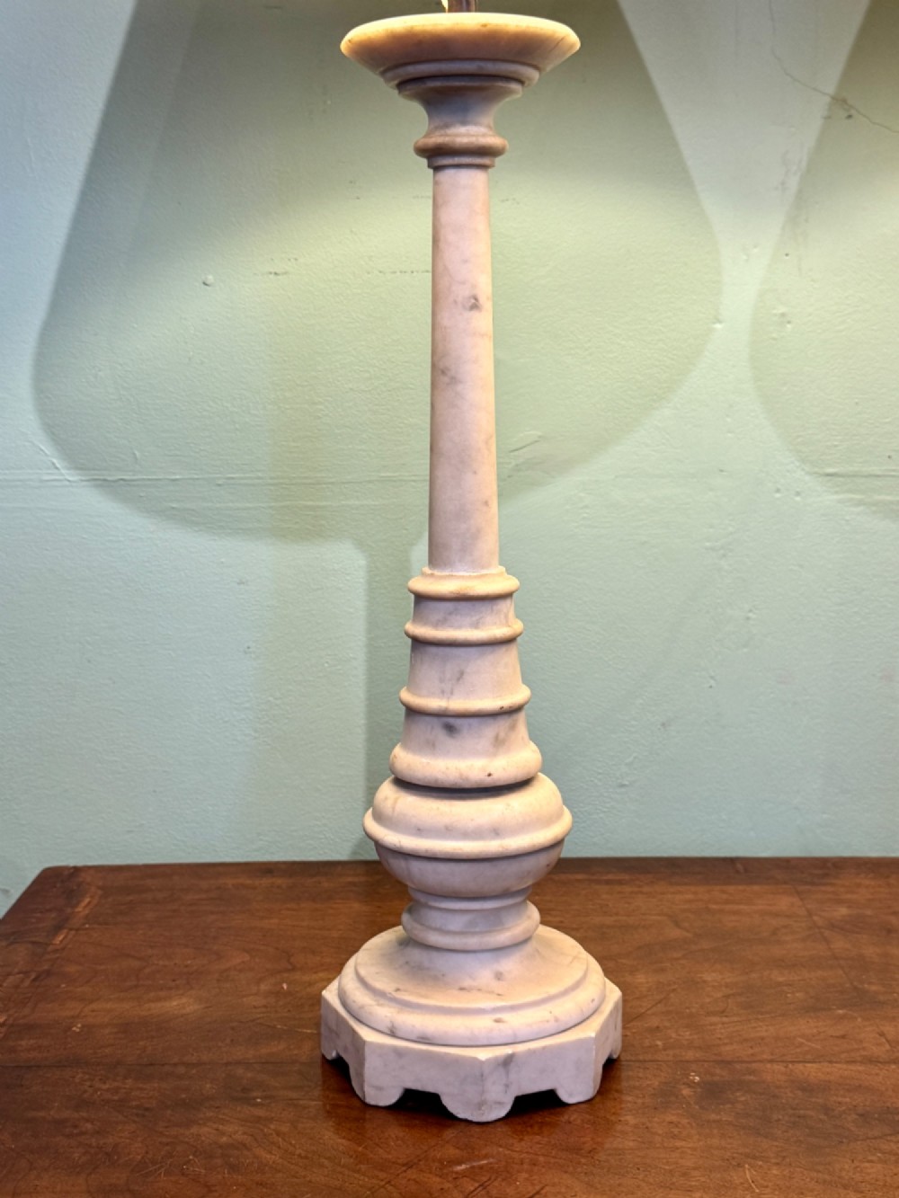 A pair of turned off-white marble table lamps featuring cylindrical baluster shafts, stepped circular bases, and cream pleated fabric shades. View VI