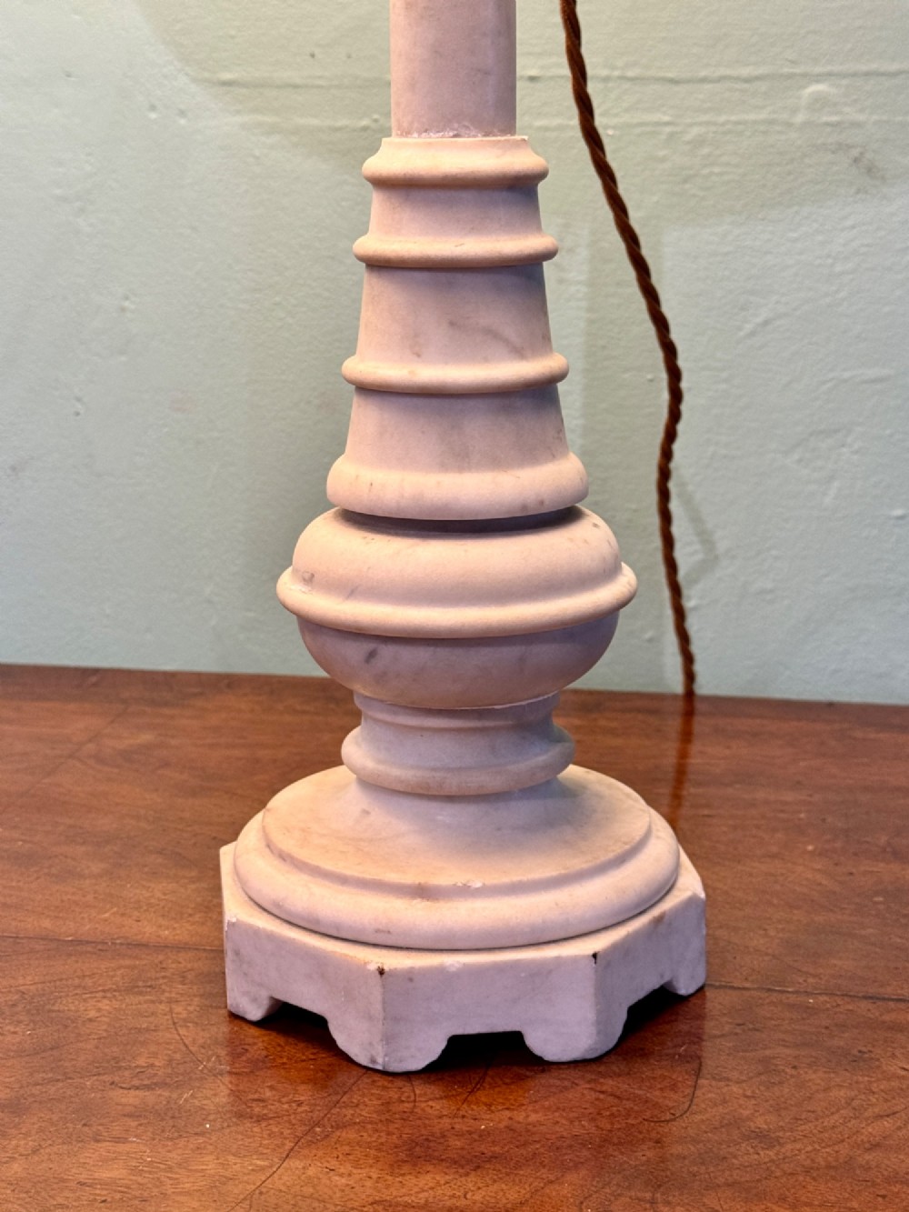 A pair of turned off-white marble table lamps featuring cylindrical baluster shafts, stepped circular bases, and cream pleated fabric shades. View VII