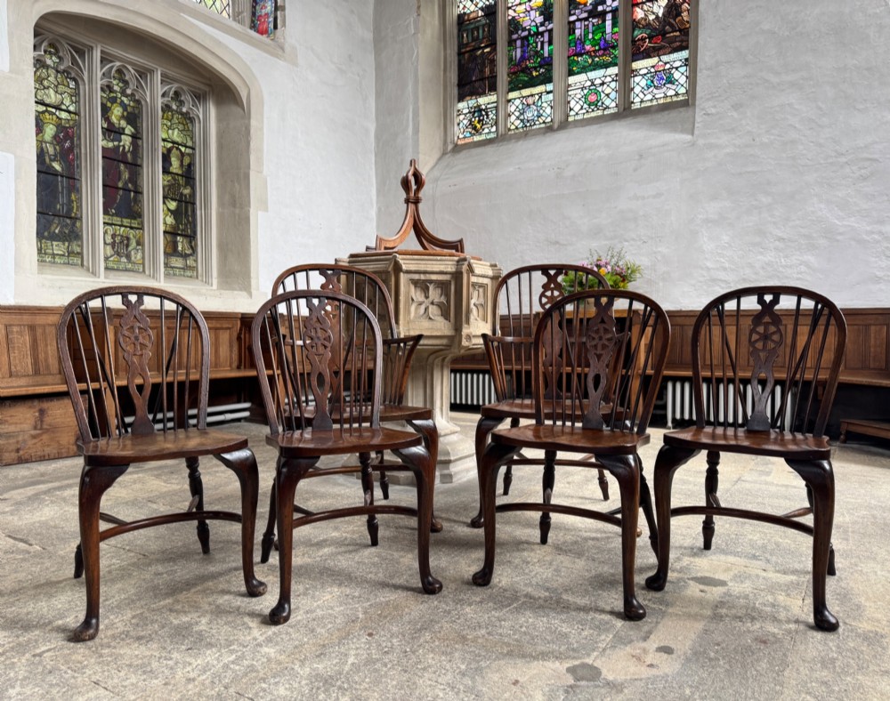 A set of six antique ash and beech Windsor chairs featuring arched backs with wheelback splats, shaped solid seats, and front cabriole legs. View II