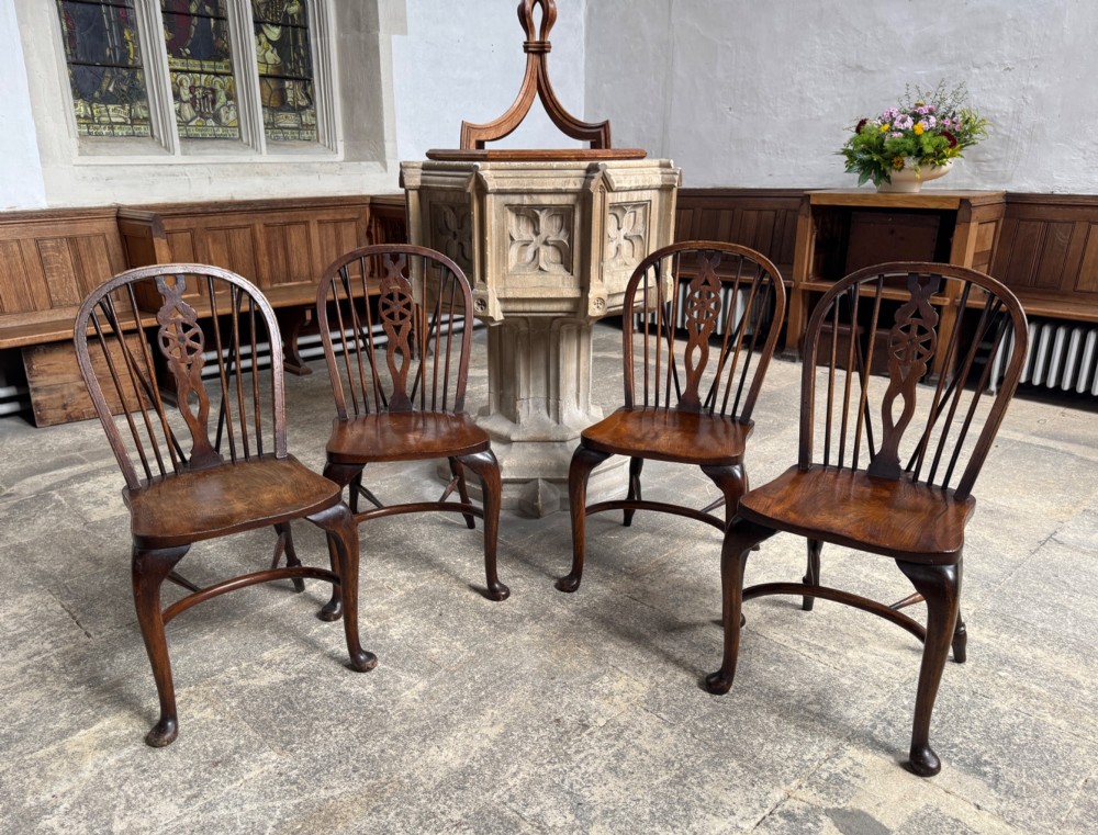 A set of six antique ash and beech Windsor chairs featuring arched backs with wheelback splats, shaped solid seats, and front cabriole legs. View V