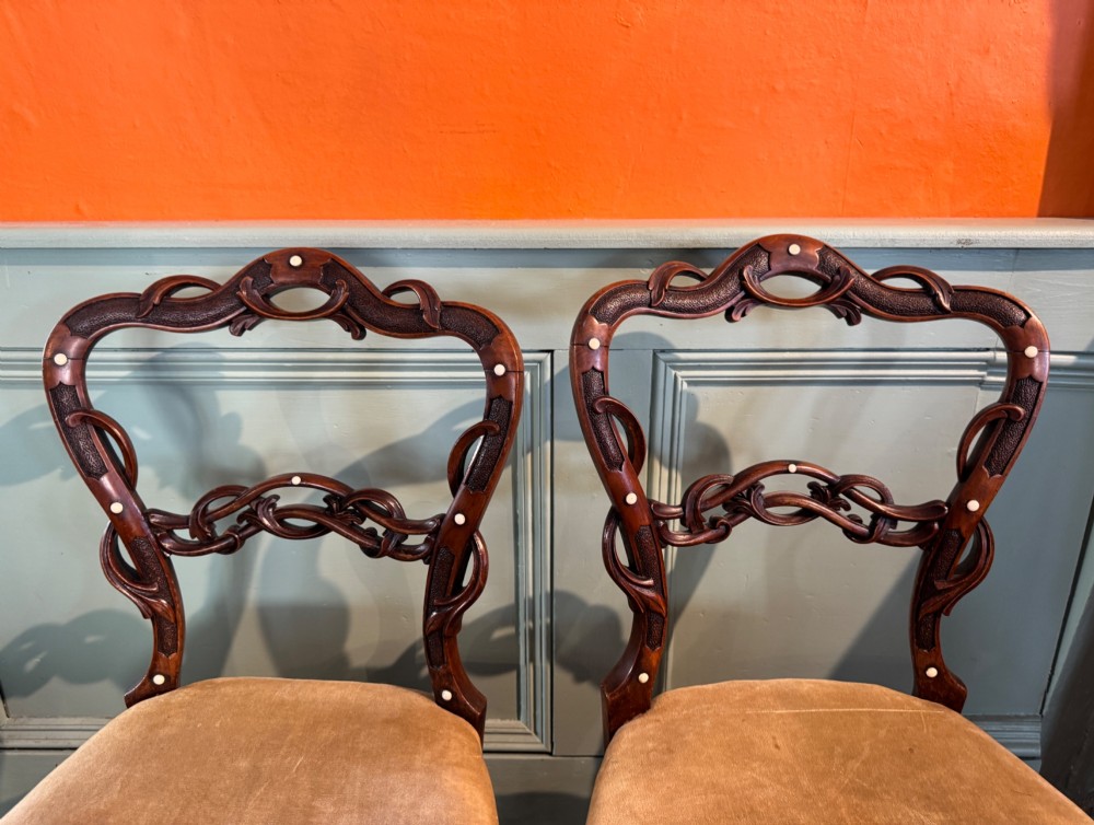 A pair of Victorian dark wood bedroom chairs with pierced scroll carved backrests, dot inlay, turned legs, and velvet seats. View III