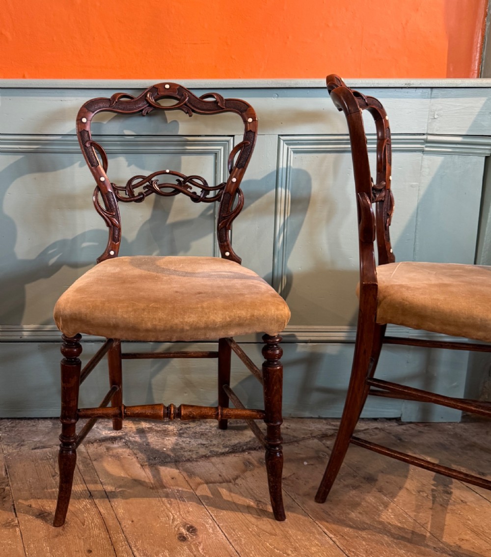 A pair of Victorian dark wood bedroom chairs with pierced scroll carved backrests, dot inlay, turned legs, and velvet seats. View IV