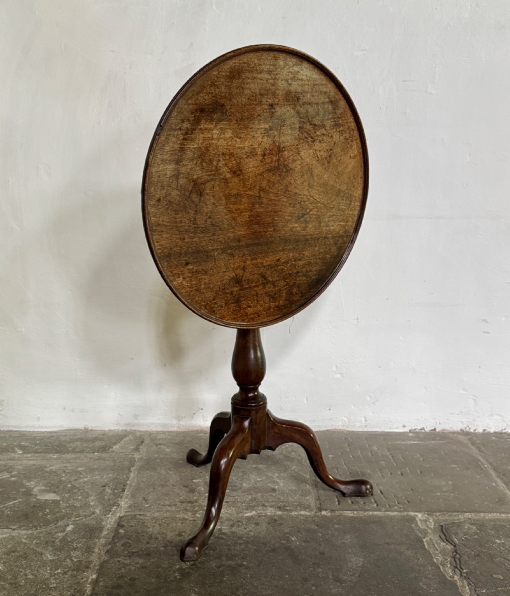 A Georgian mahogany tilt-top tripod table featuring a circular dished top supported by a turned pedestal stem and three cabriole legs. View III
