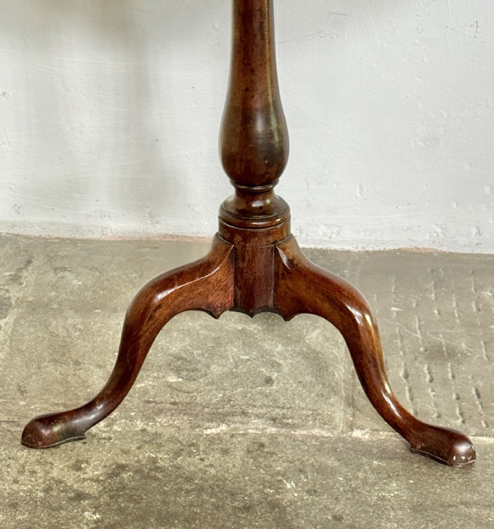 A Georgian mahogany tilt-top tripod table featuring a circular dished top supported by a turned pedestal stem and three cabriole legs. View V