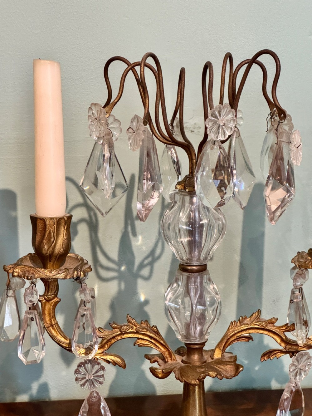 A pair of French gilt-brass two-arm candlestick lustres featuring central crystal elements and hanging cut-crystal drop prisms. View IV