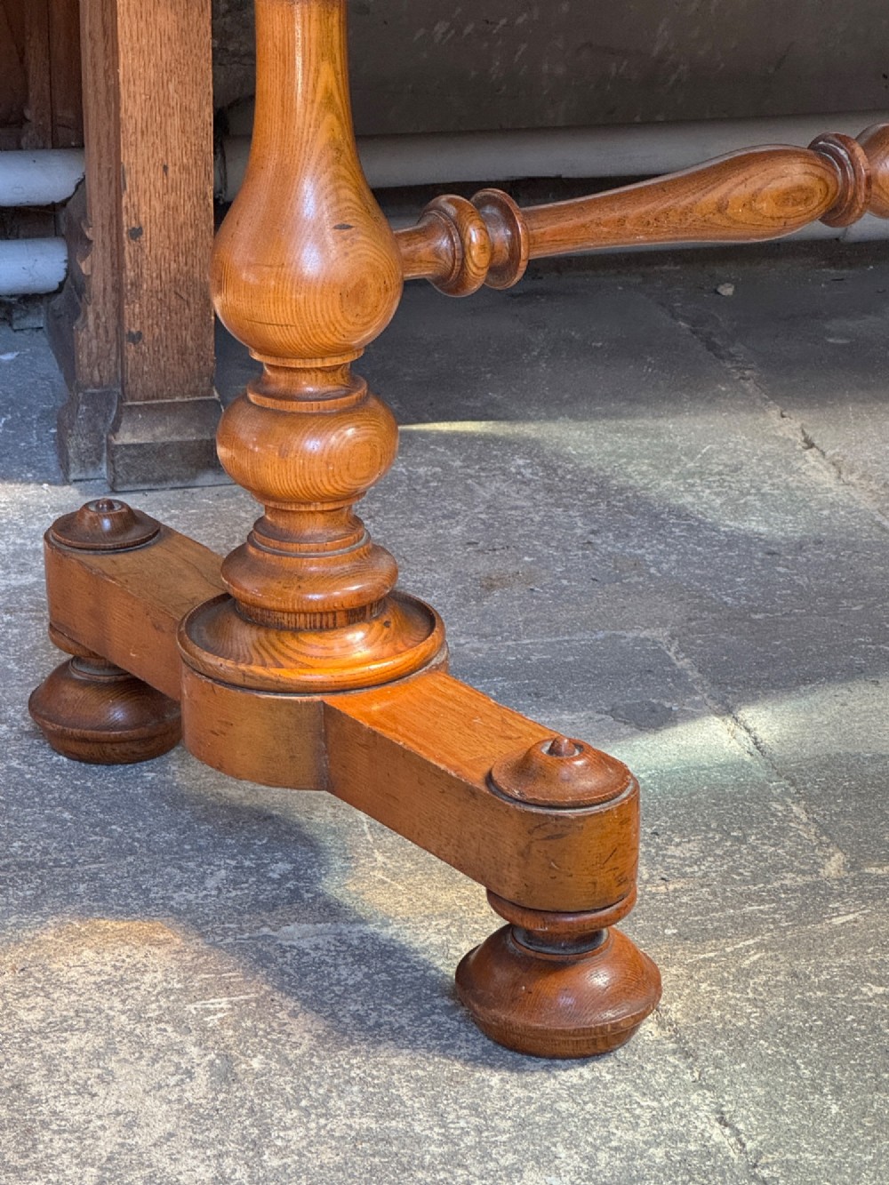 A Victorian pitch pine washstand featuring a raised gallery splashback, a single wide drawer with wooden knobs, and turned trestle legs connected by a stretcher. View VII