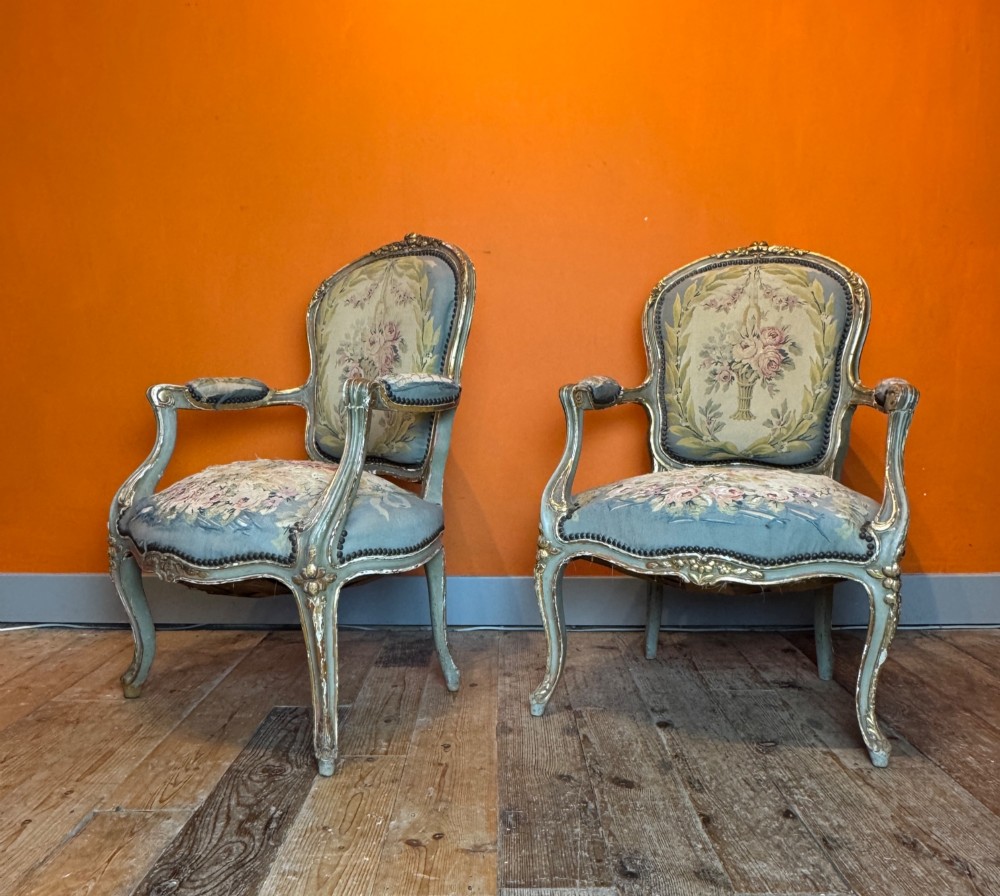 A pair of 19th-century French parcel gilt and painted armchairs featuring curved cabriole legs and floral tapestry upholstery. View II