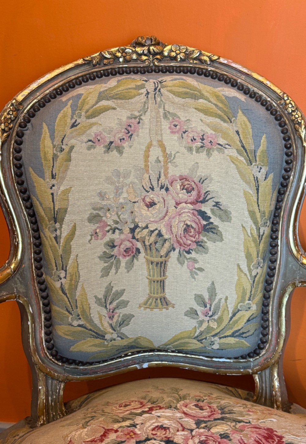 A pair of 19th-century French parcel gilt and painted armchairs featuring curved cabriole legs and floral tapestry upholstery. View V