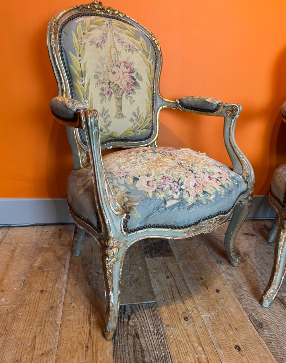 A pair of 19th-century French parcel gilt and painted armchairs featuring curved cabriole legs and floral tapestry upholstery. View VI