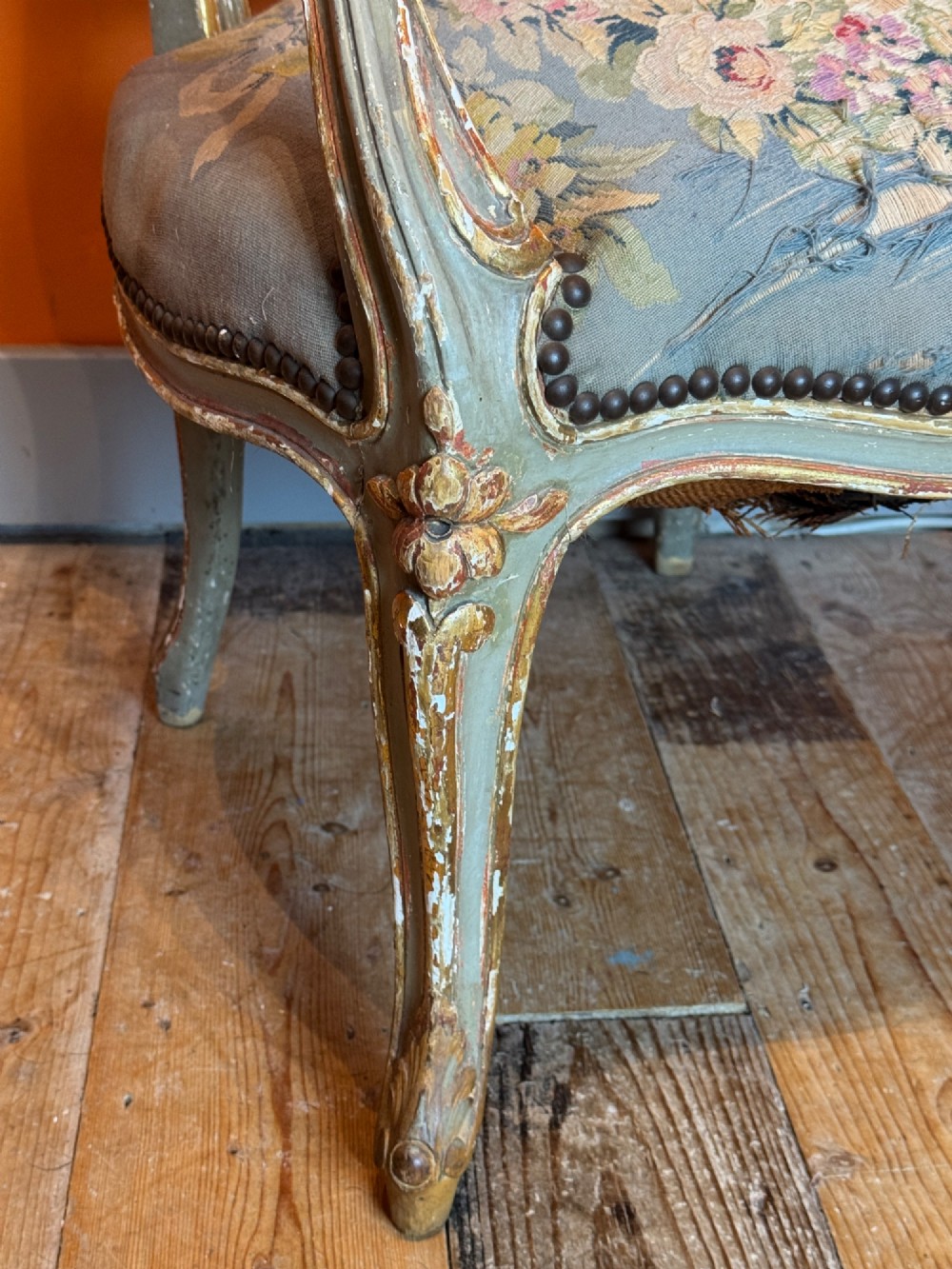 A pair of 19th-century French parcel gilt and painted armchairs featuring curved cabriole legs and floral tapestry upholstery. View VII