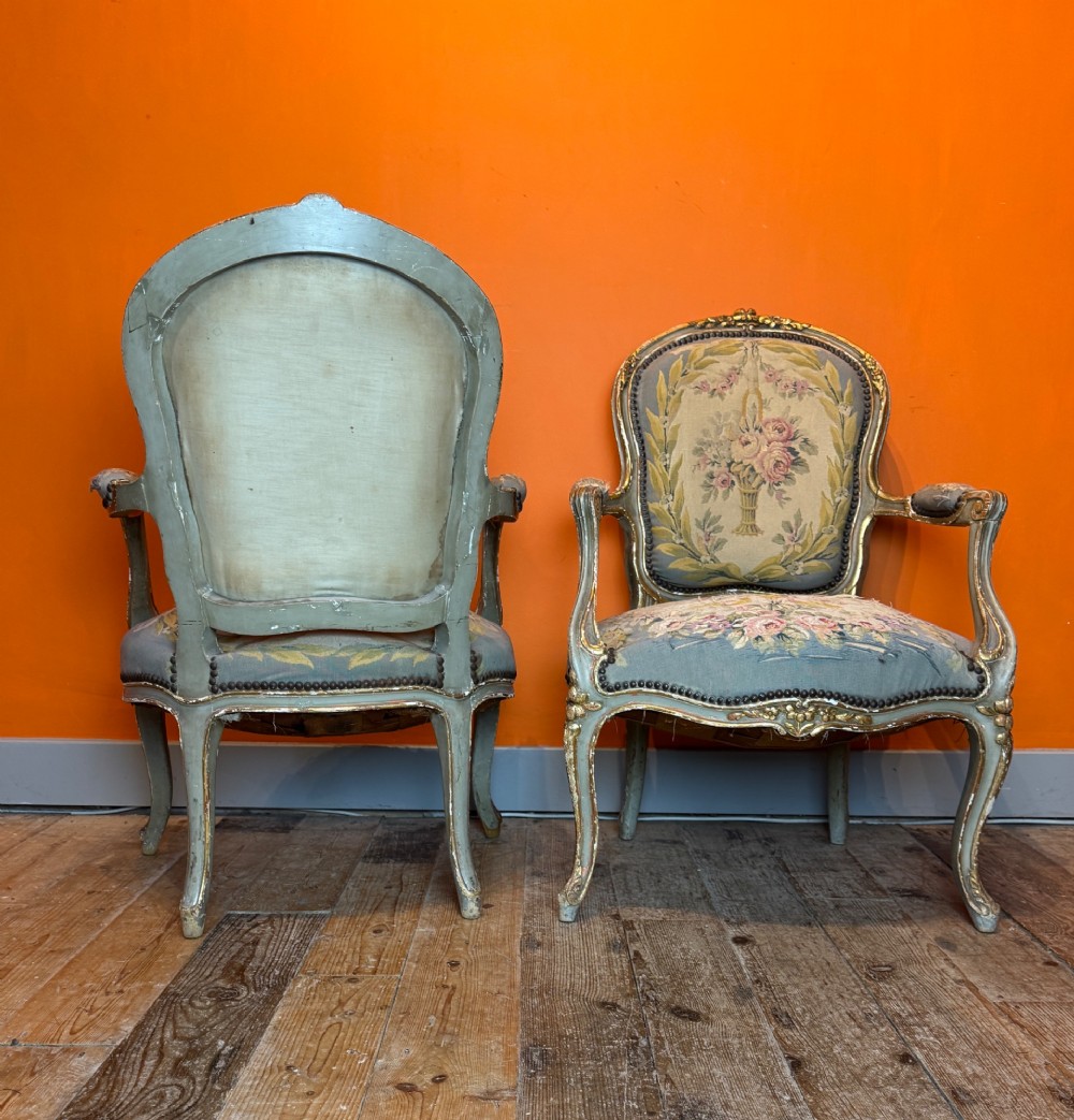 A pair of 19th-century French parcel gilt and painted armchairs featuring curved cabriole legs and floral tapestry upholstery. View VIII
