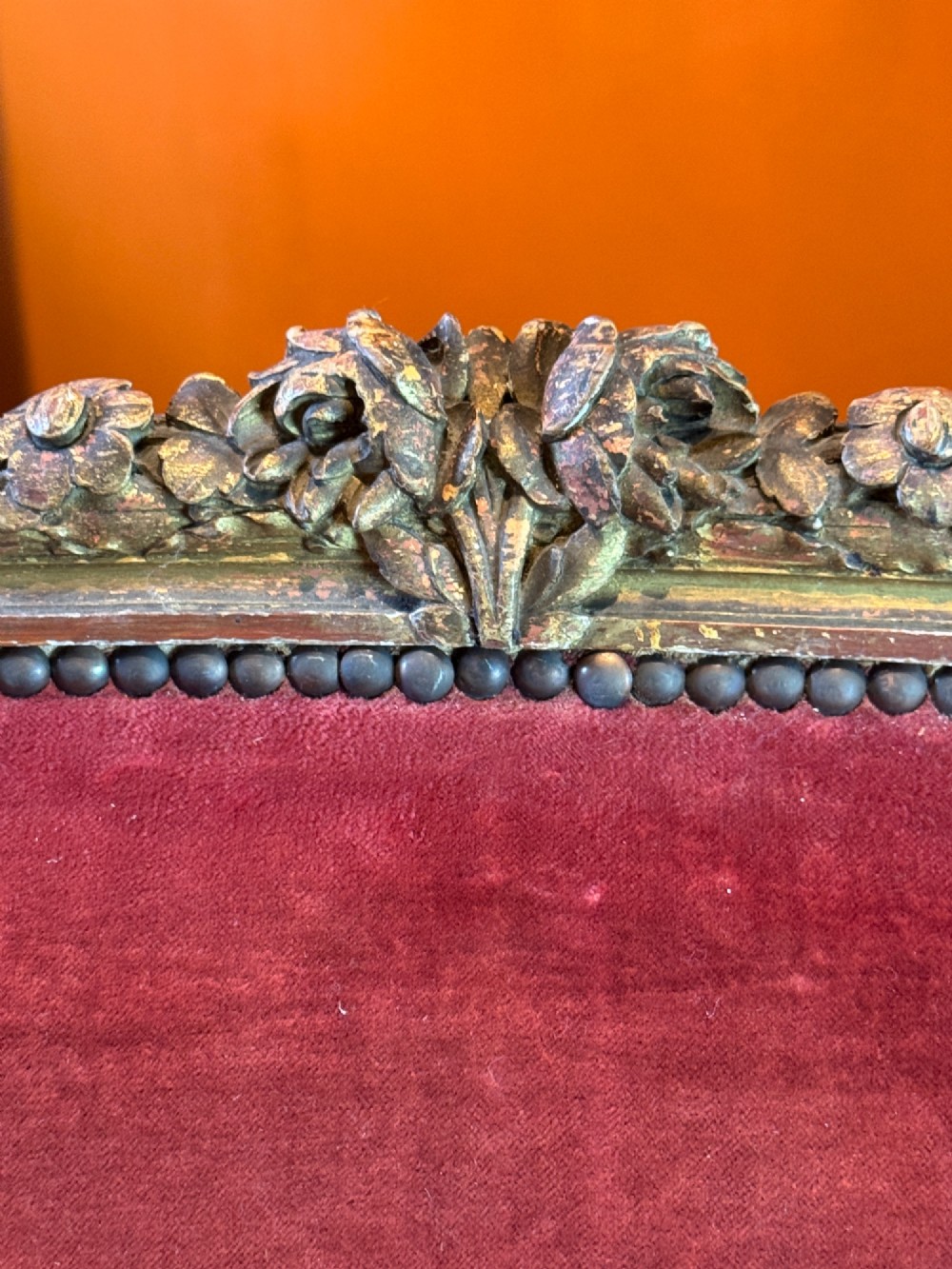 An antique French Louis XVI style two-seat corbeille sofa featuring a carved giltwood frame and deep crimson red velvet upholstery. View VI