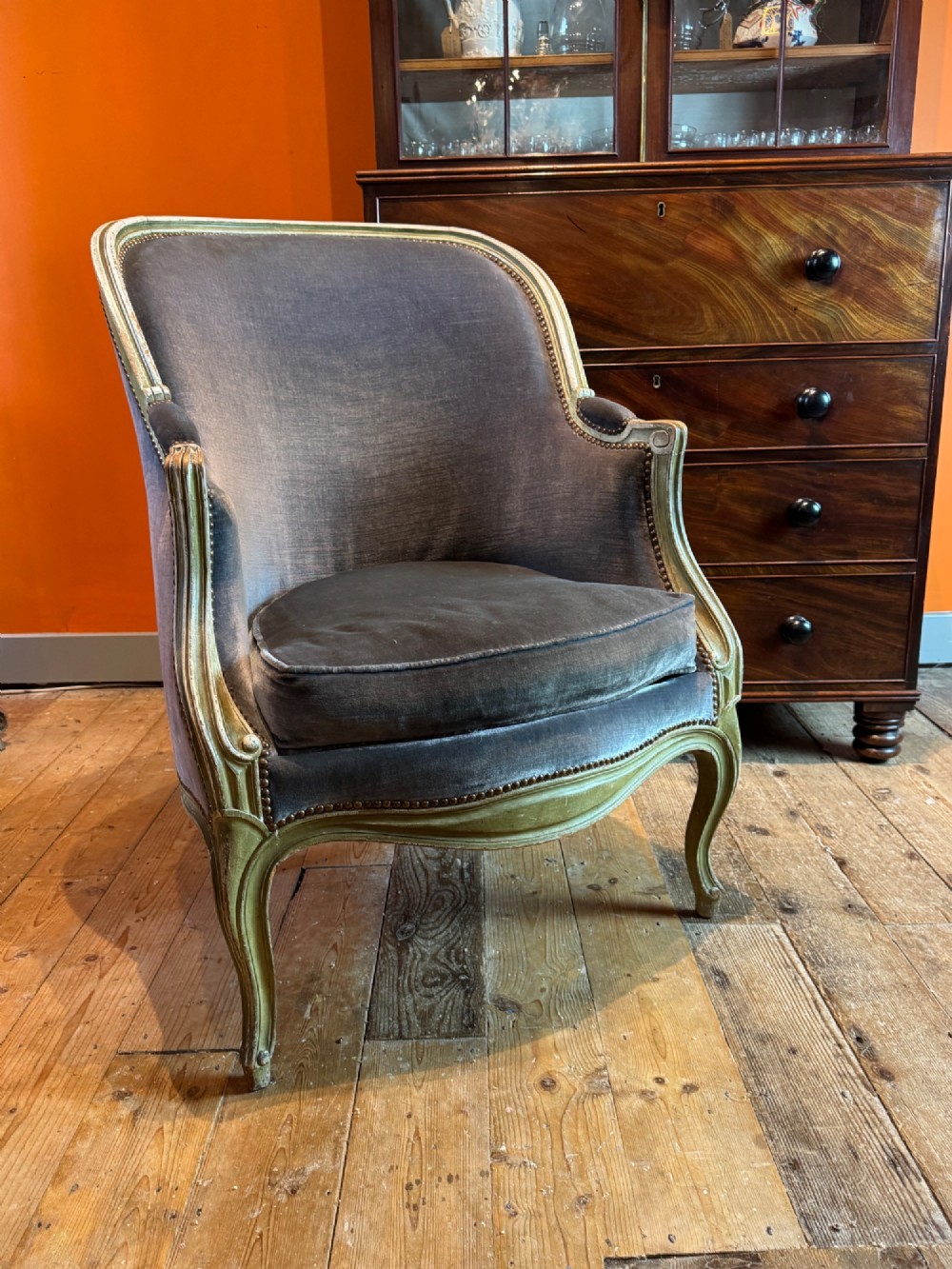 An antique Louis XV style tub bergere armchair upholstered in slate grey velvet with a carved distressed green wooden frame and cabriole legs. View III