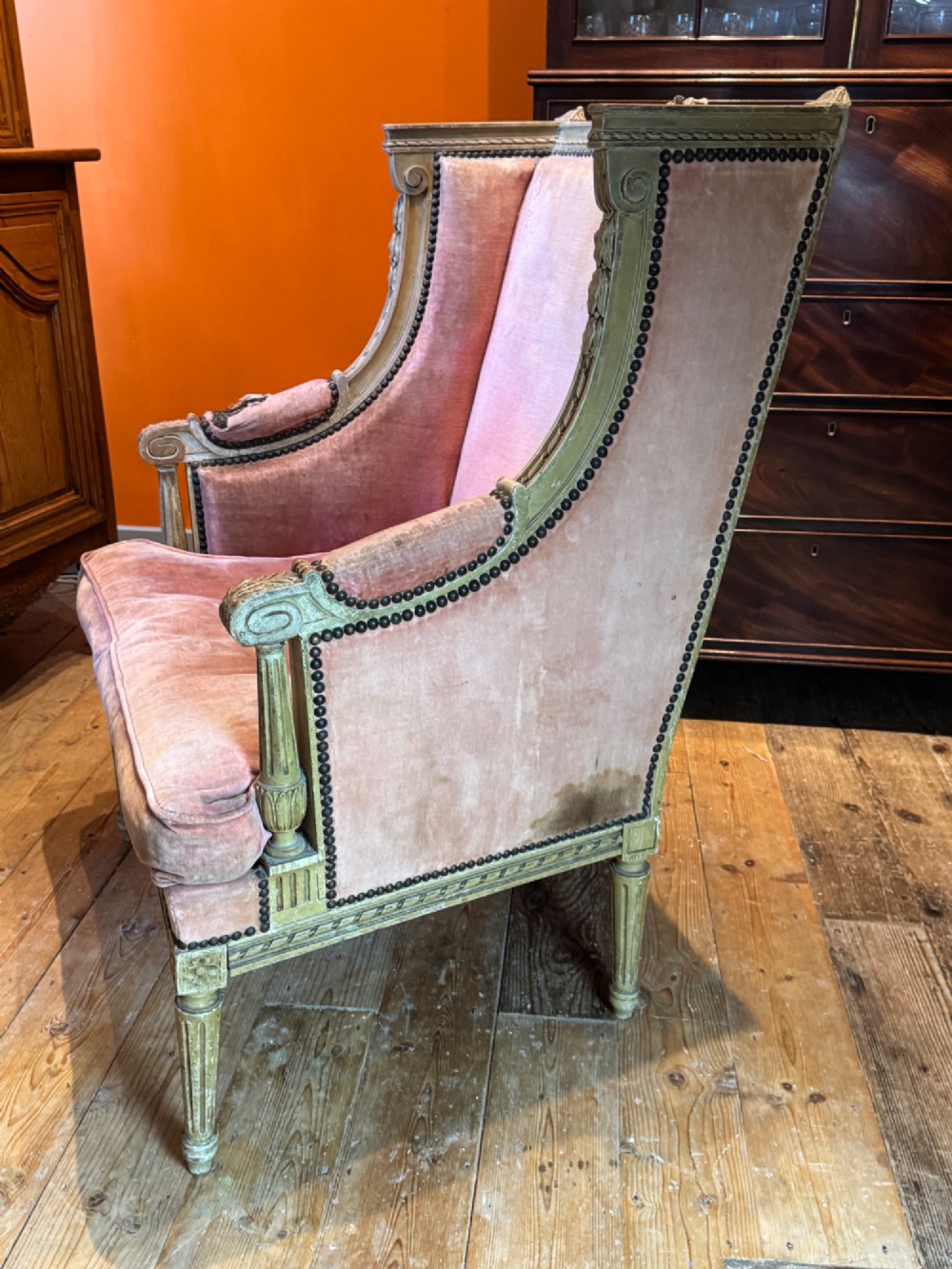 An antique Louis XVI French bergere armchair with a grey painted carved wood frame and dusty pink velvet upholstery. View VI