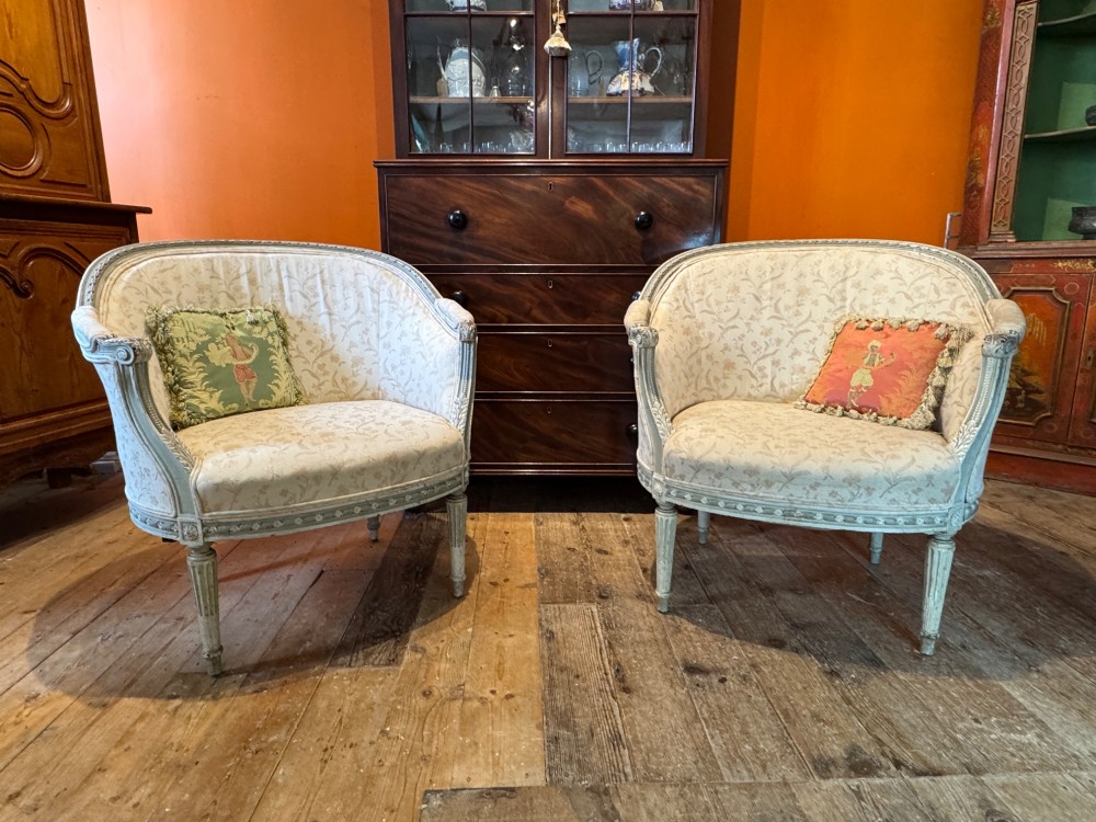 A pair of French tub armchairs featuring distressed cream painted carved wooden frames and light floral upholstery. View III