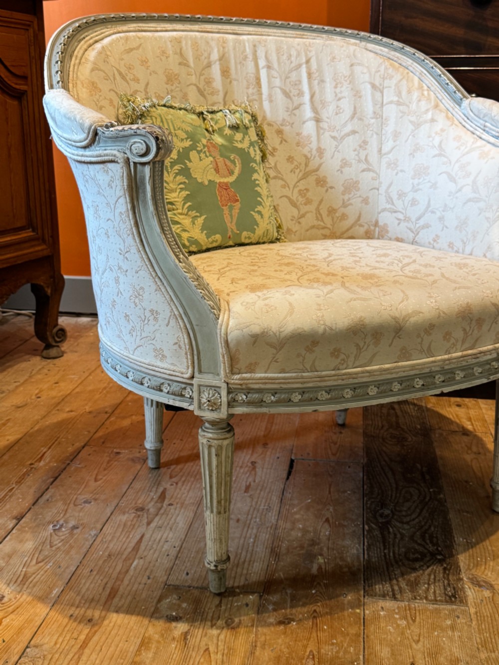 A pair of French tub armchairs featuring distressed cream painted carved wooden frames and light floral upholstery. View IV