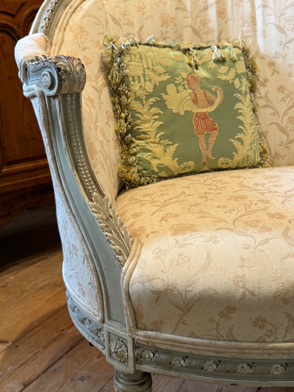 A pair of French tub armchairs featuring distressed cream painted carved wooden frames and light floral upholstery. View V