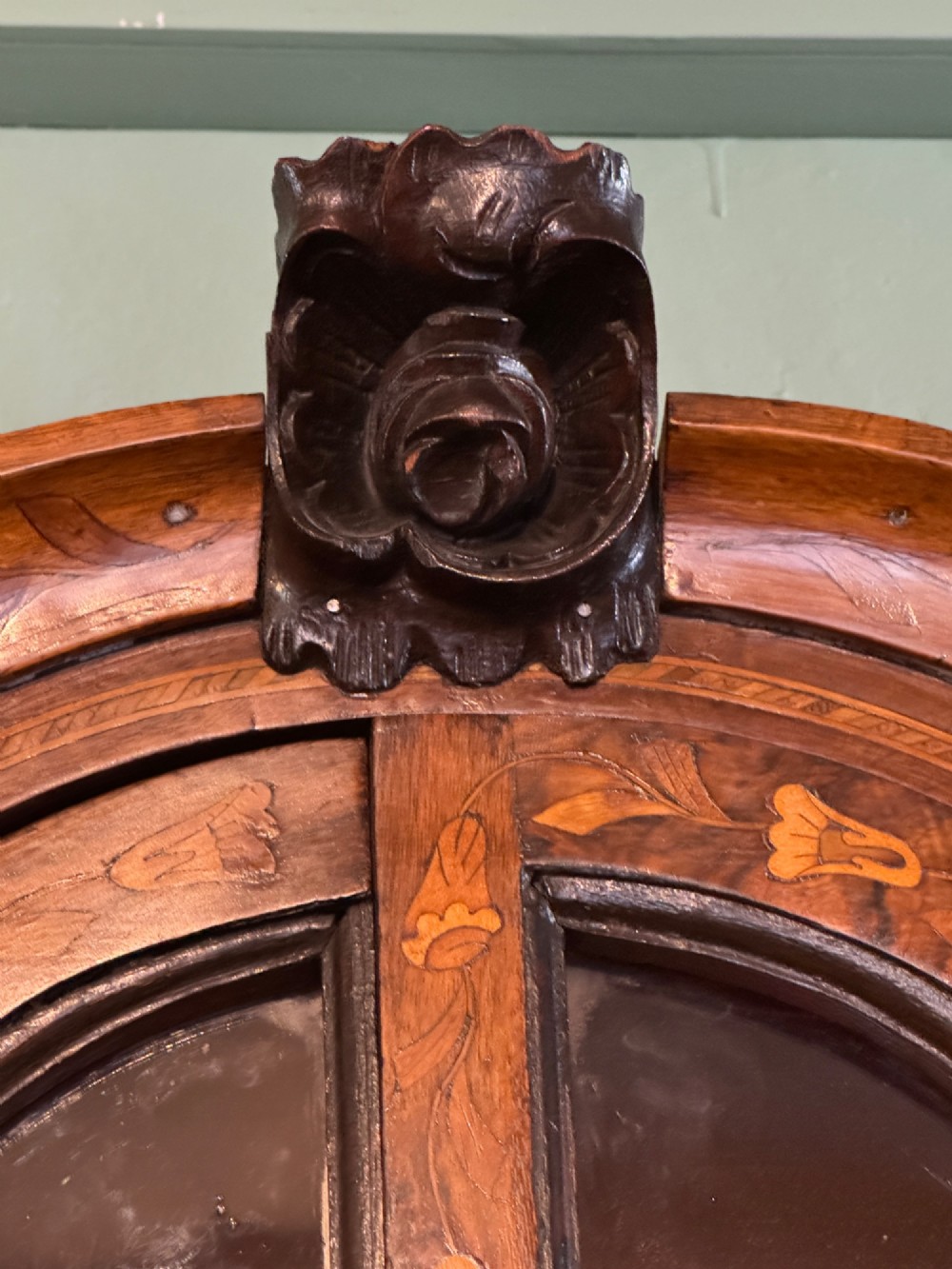 An antique Dutch walnut display cabinet featuring intricate floral marquetry inlays, glazed upper doors, and a double cupboard lower section supported by bun feet. View XI