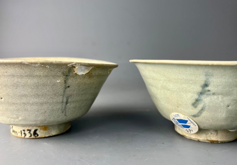 A pair of small antique Chinese porcelain bowls with flared rims, raised foot rings, and pale greenish-white glazed finishes displaying subtle surface accretions. View II