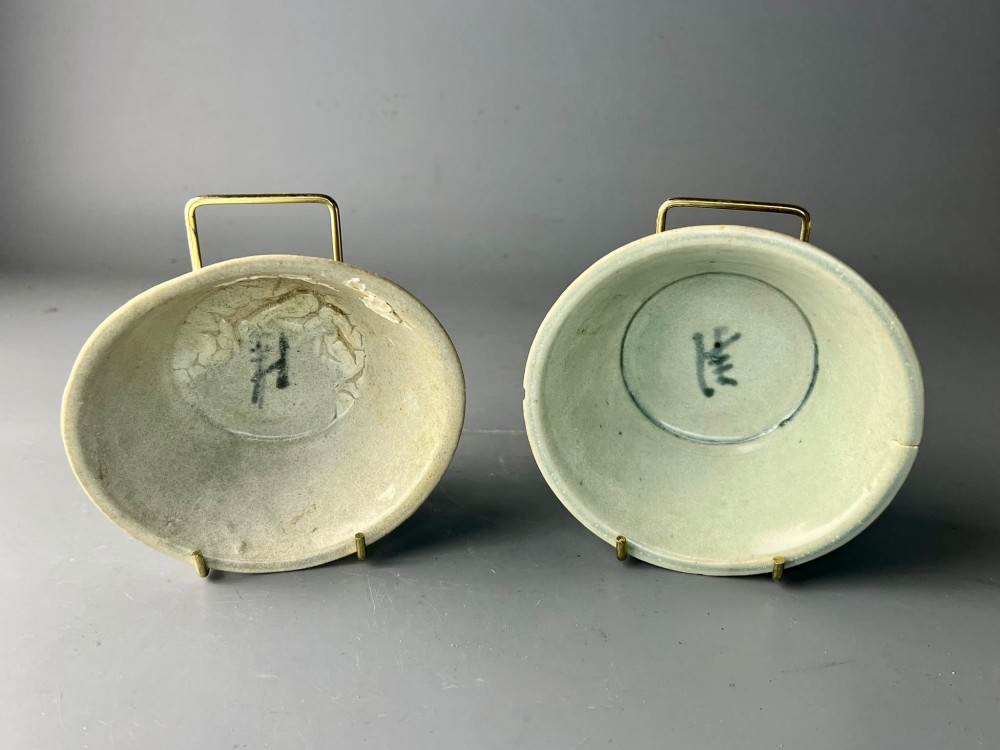 A pair of small antique Chinese porcelain bowls with flared rims, raised foot rings, and pale greenish-white glazed finishes displaying subtle surface accretions. View III