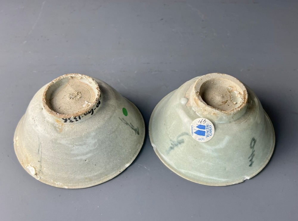 A pair of small antique Chinese porcelain bowls with flared rims, raised foot rings, and pale greenish-white glazed finishes displaying subtle surface accretions. View IV