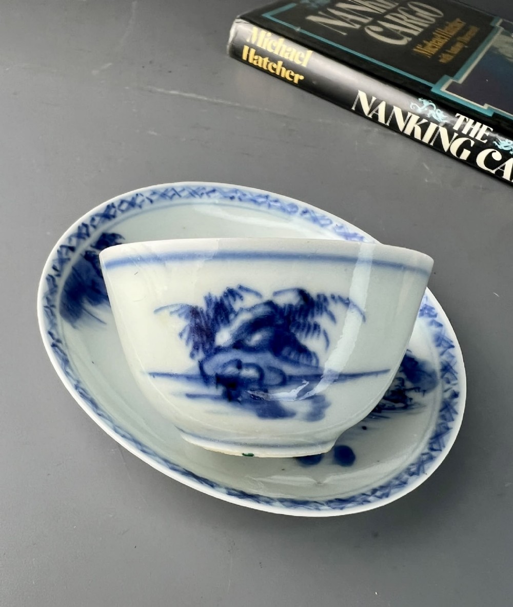 An 18th-century Chinese export blue and white porcelain tea bowl resting inside its matching hand-painted saucer.