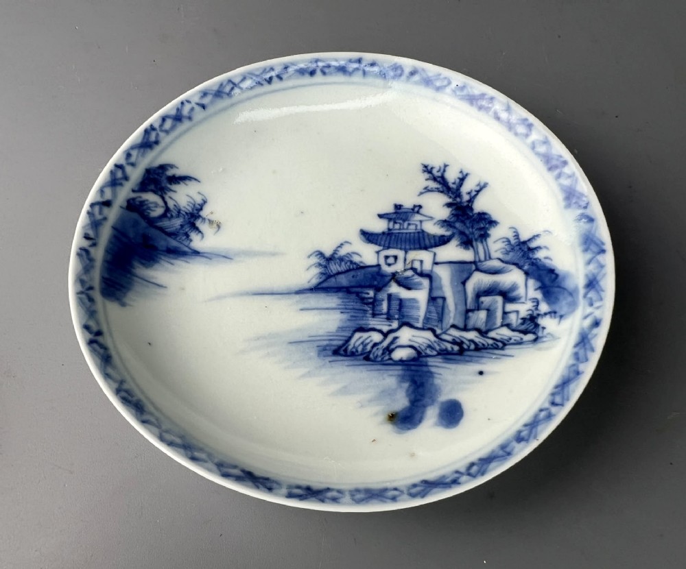An 18th-century Chinese export blue and white porcelain tea bowl resting inside its matching hand-painted saucer. View VI