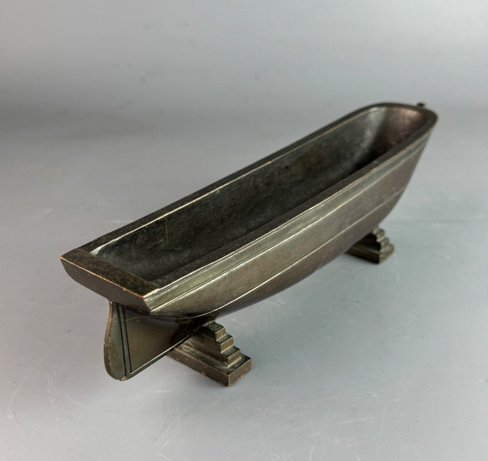 An Art Deco dark bronze pen tray designed in the form of a boat hull mounted on two stepped support feet. View IV