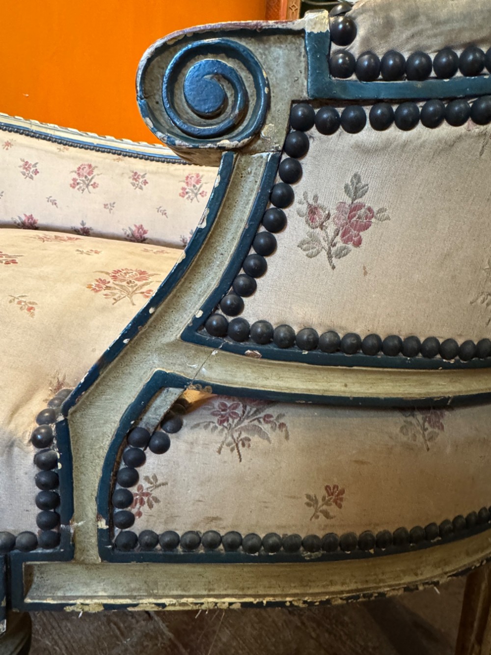 An antique French Louis XVI style duchesse brisee chaise with a distressed off-white painted wooden frame, fluted legs, and floral upholstery. View IV