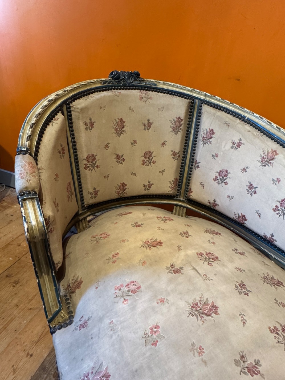 An antique French Louis XVI style duchesse brisee chaise with a distressed off-white painted wooden frame, fluted legs, and floral upholstery. View V