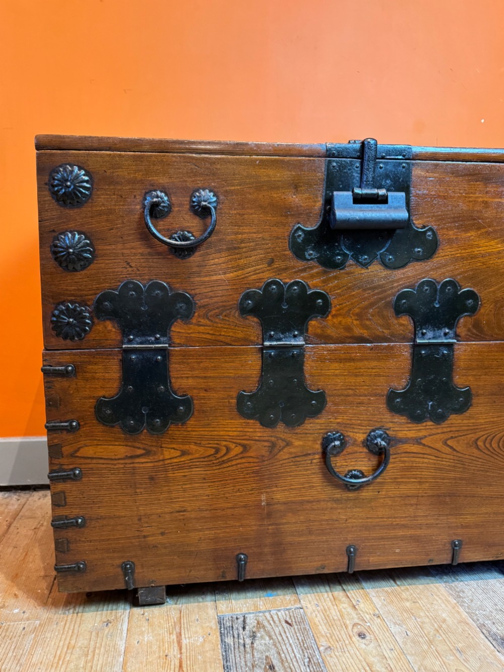 An antique wooden Korean Bandaji chest fitted with black iron strap hinges, decorative round bosses, and drop handles. View IV
