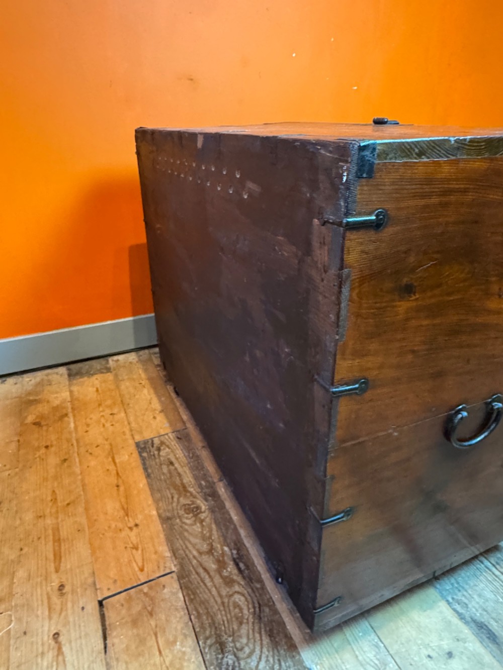 An antique wooden Korean Bandaji chest fitted with black iron strap hinges, decorative round bosses, and drop handles. View IX