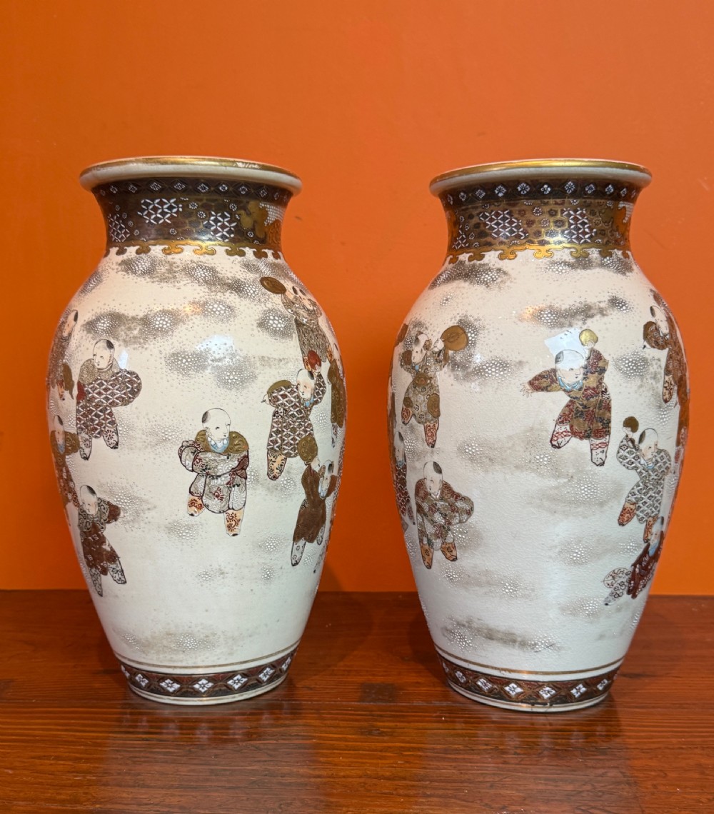 A pair of baluster-shaped Japanese Satsuma earthenware vases featuring hand-painted figures in the Hundred Boys pattern with gilded borders and a crackle glaze. View V