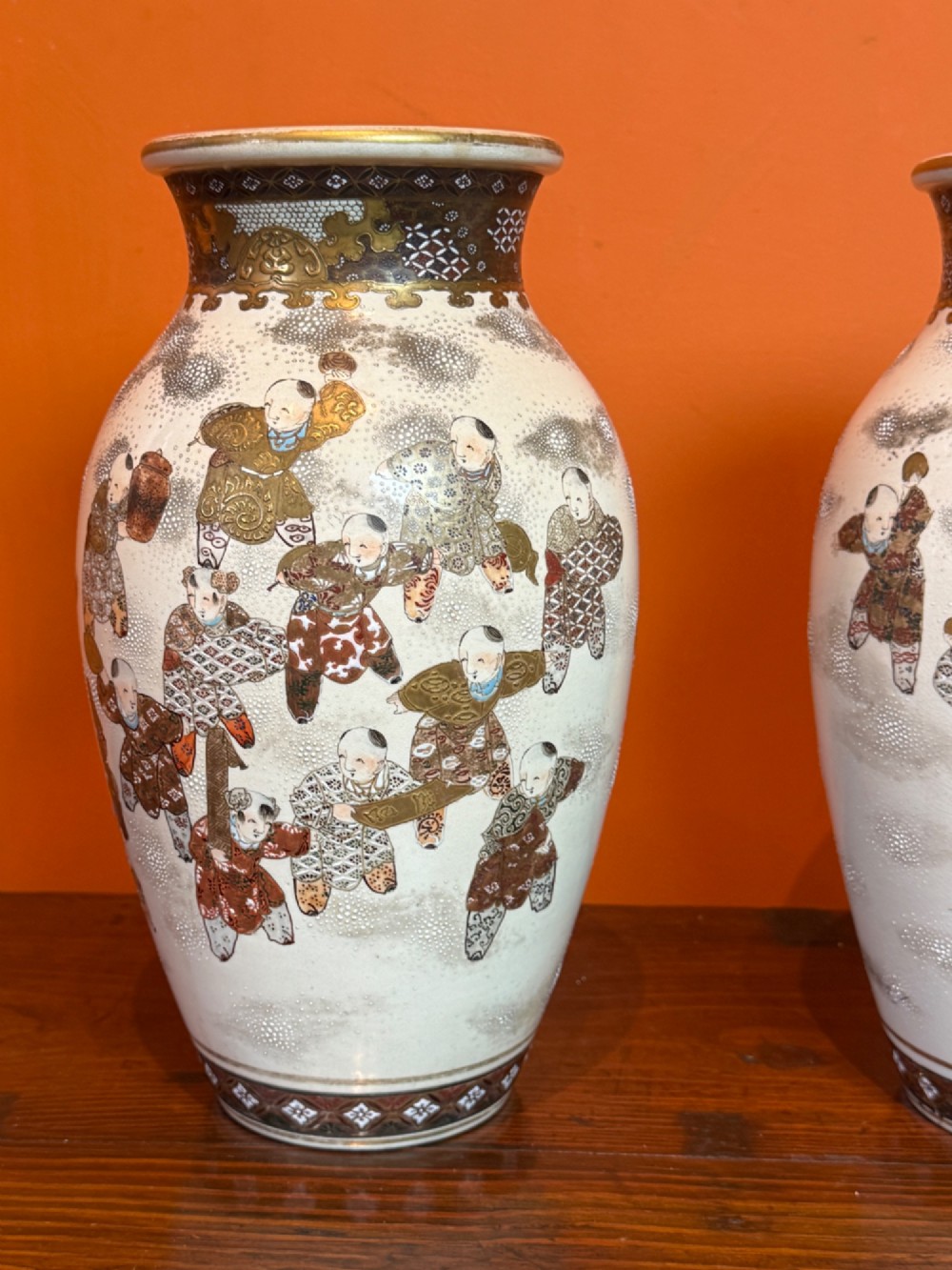 A pair of baluster-shaped Japanese Satsuma earthenware vases featuring hand-painted figures in the Hundred Boys pattern with gilded borders and a crackle glaze. View VI