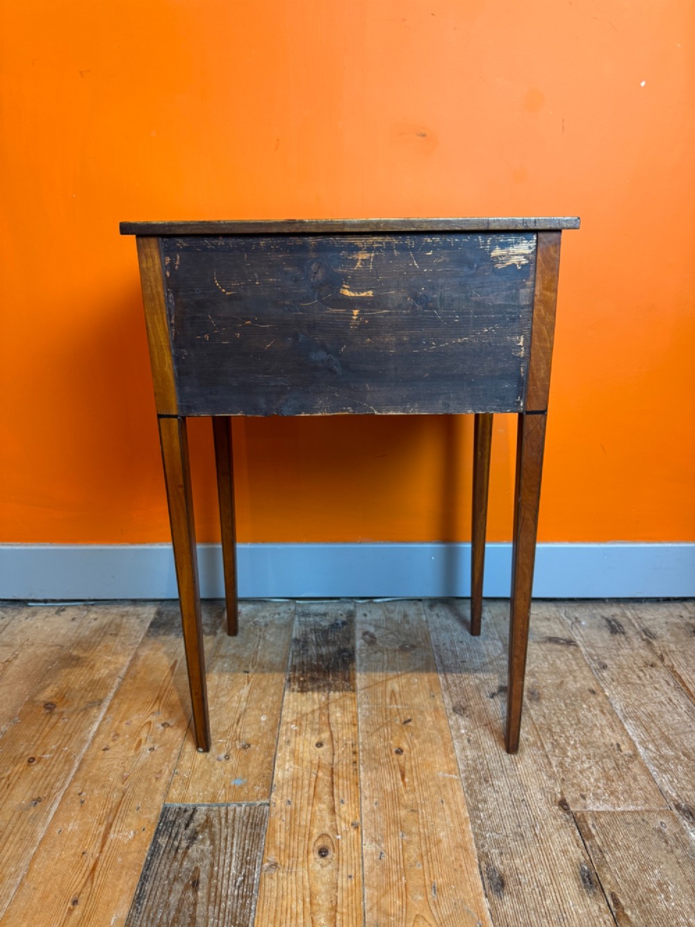 A Sheraton style satinwood side table featuring two crossbanded drawers with round brass pulls and square tapered legs. View VIII