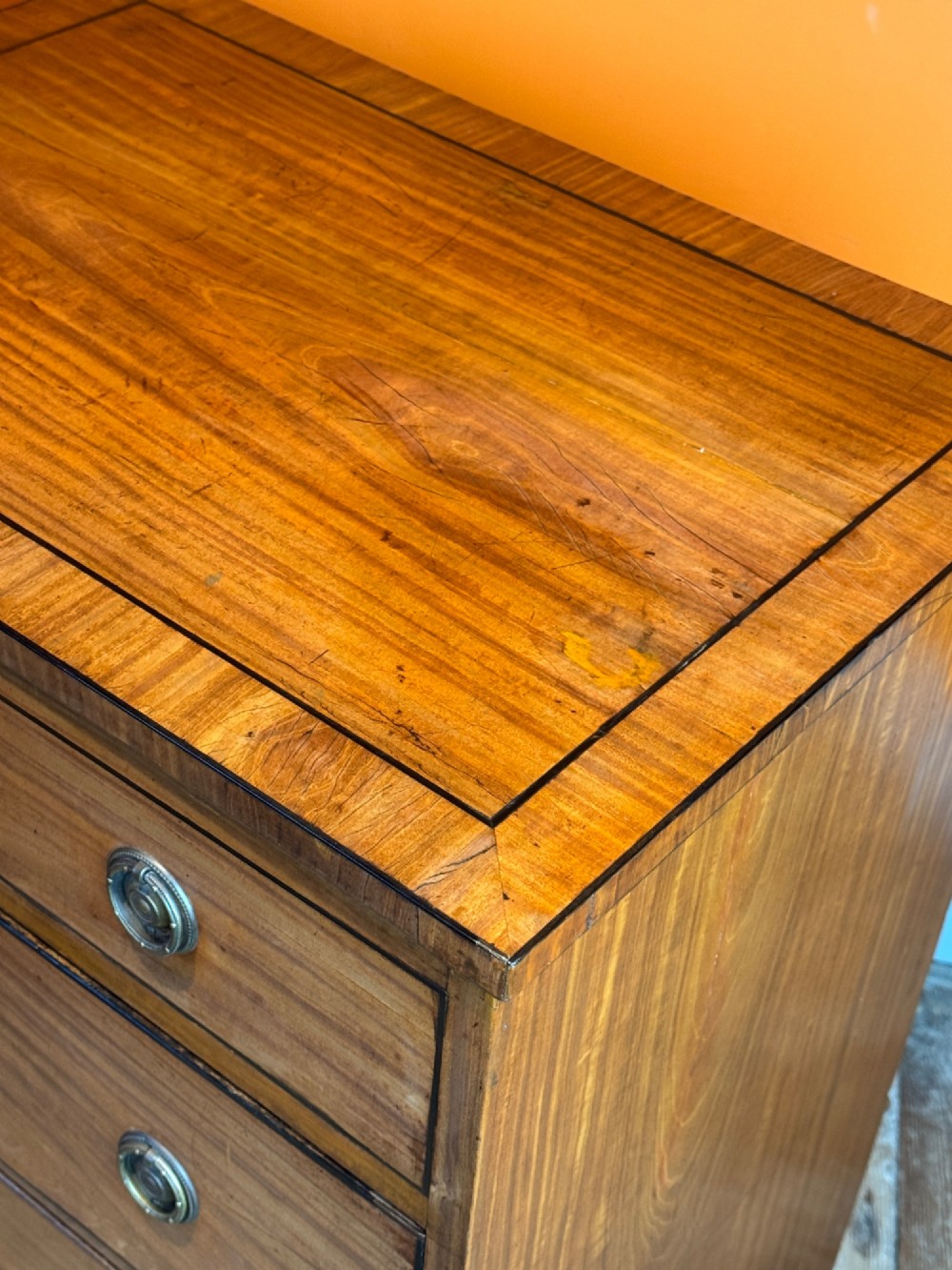 A small Regency satinwood chest of three graduated drawers with brass handles and string inlay. View III