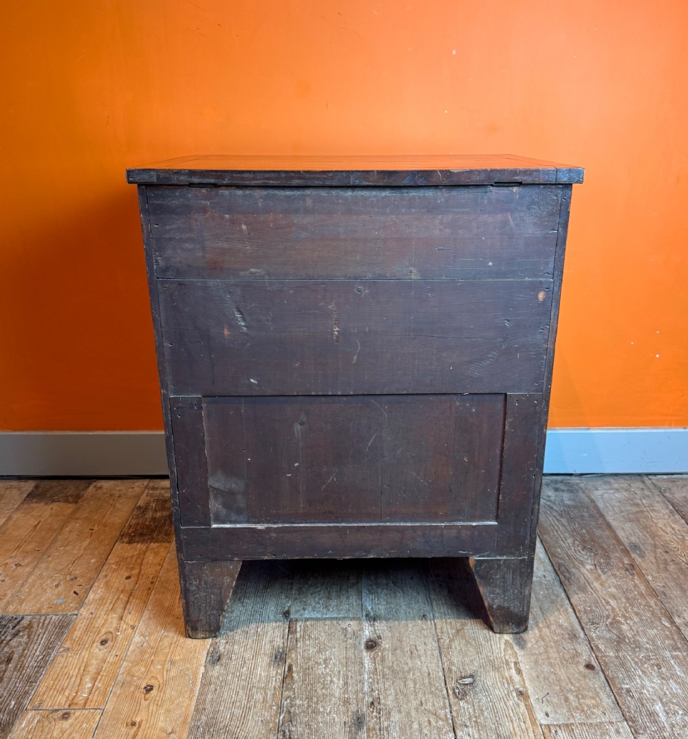 A small Regency satinwood chest of three graduated drawers with brass handles and string inlay. View IV