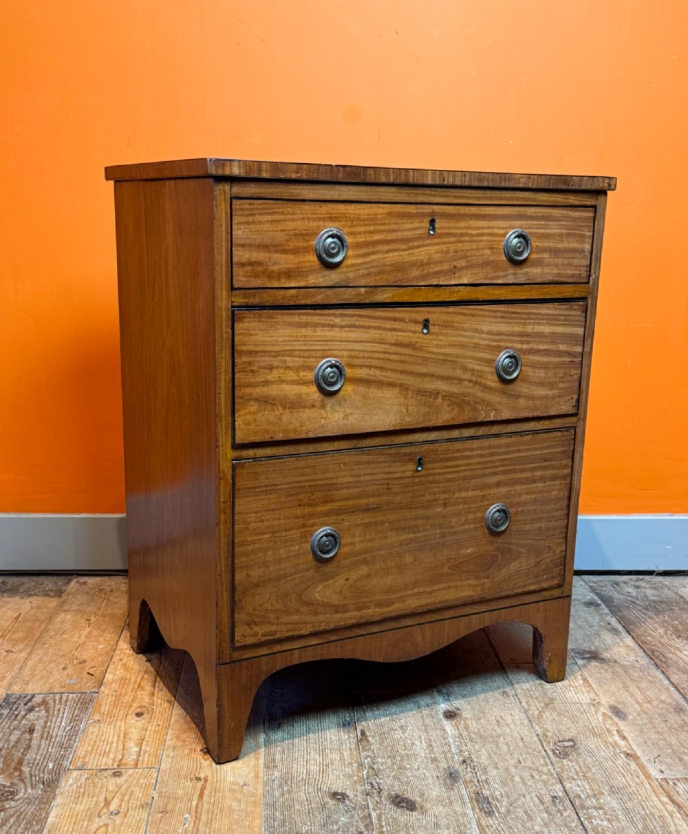 A small Regency satinwood chest of three graduated drawers with brass handles and string inlay. View VI