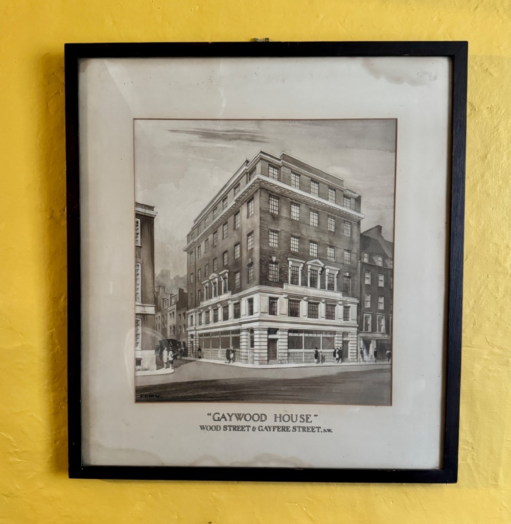A framed 1920s monochrome architectural watercolour drawing of Gaywood House in Westminster, depicted from a street corner perspective within a black frame.