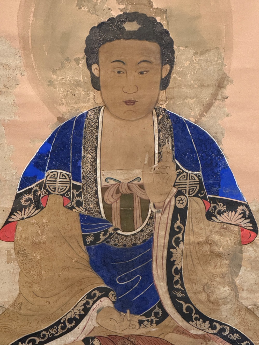 A 19th-century Chinese hanging scroll painting depicting Buddha Shakyamuni seated cross-legged on a lotus throne in blue and gold robes. View II