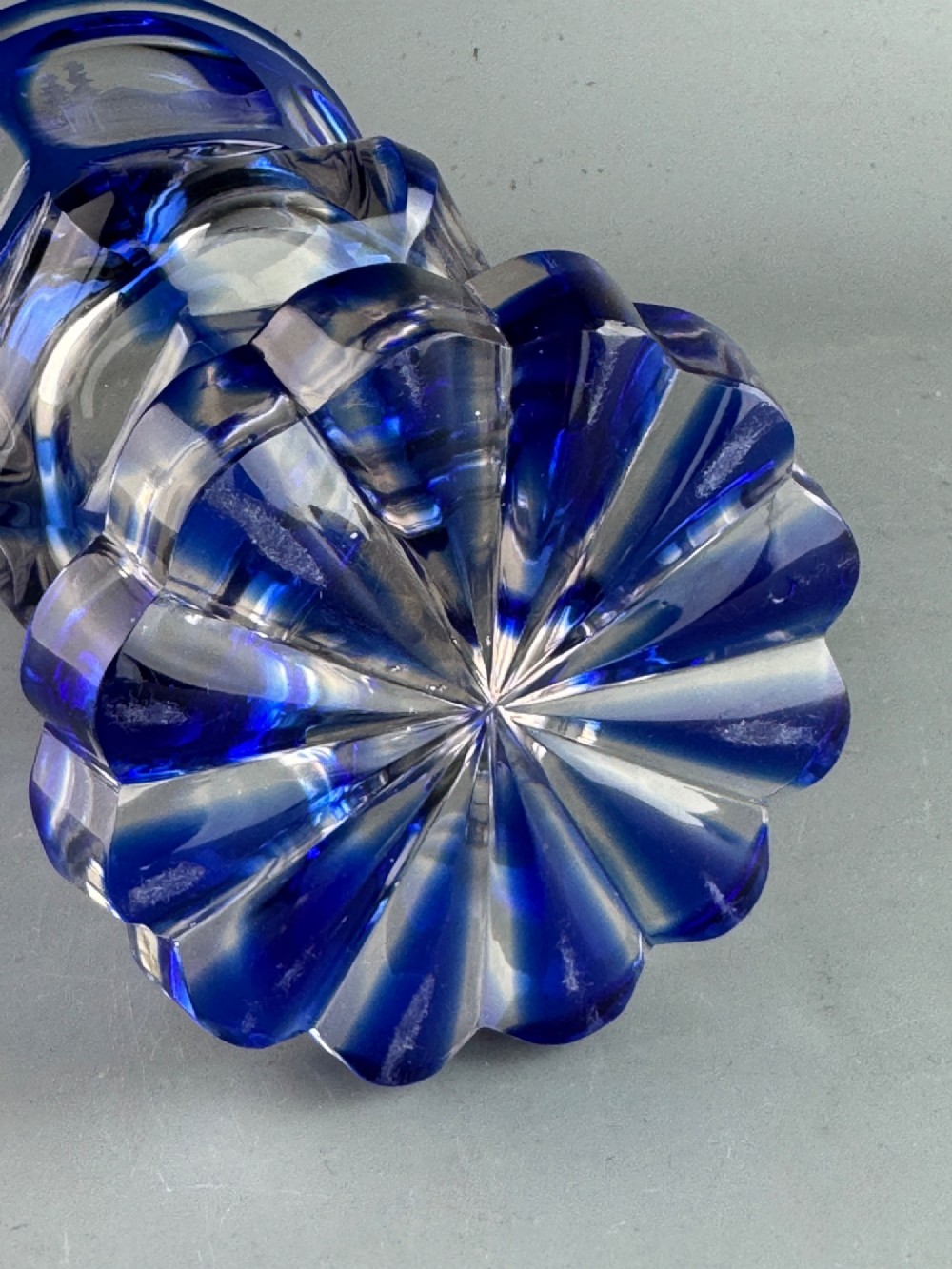 A cobalt blue cut-to-clear glass spa goblet featuring wheel-engraved architectural medallions, a faceted stem, and a starburst base. View IV