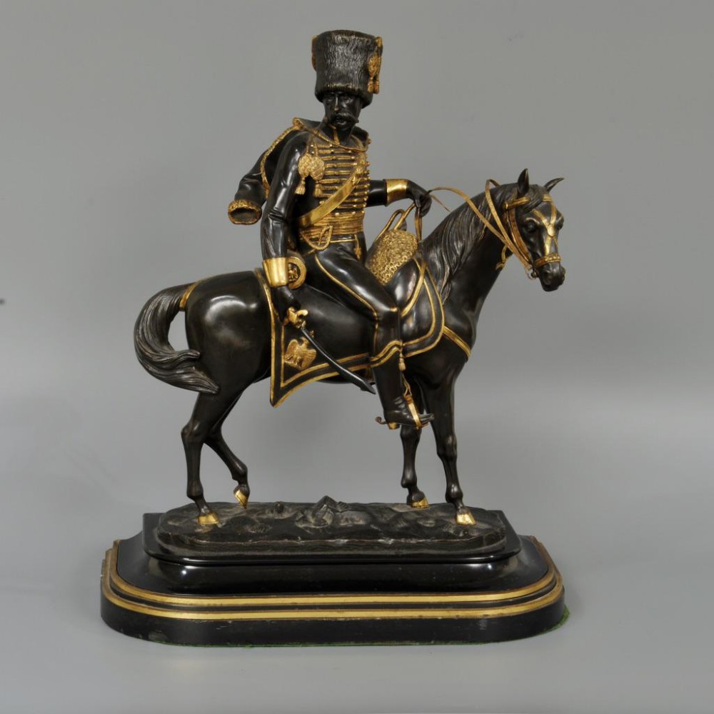 A BRONZE AND GILT FIGURE OF AN OFFICER ON HORSE BACK