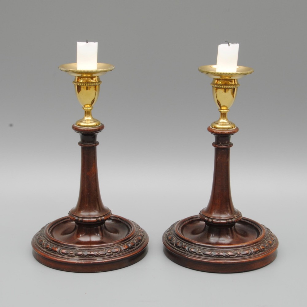 A PAIR OF 18TH CENTURY MAHOGANY AND BRASS CANDLESTICKS