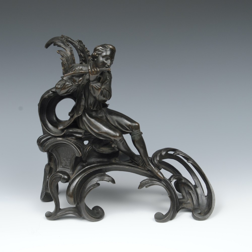 A pair of dark patinated bronze 19th-century French Rococo style chenets featuring sculpted figures seated atop elaborate scrollwork bases. View IV