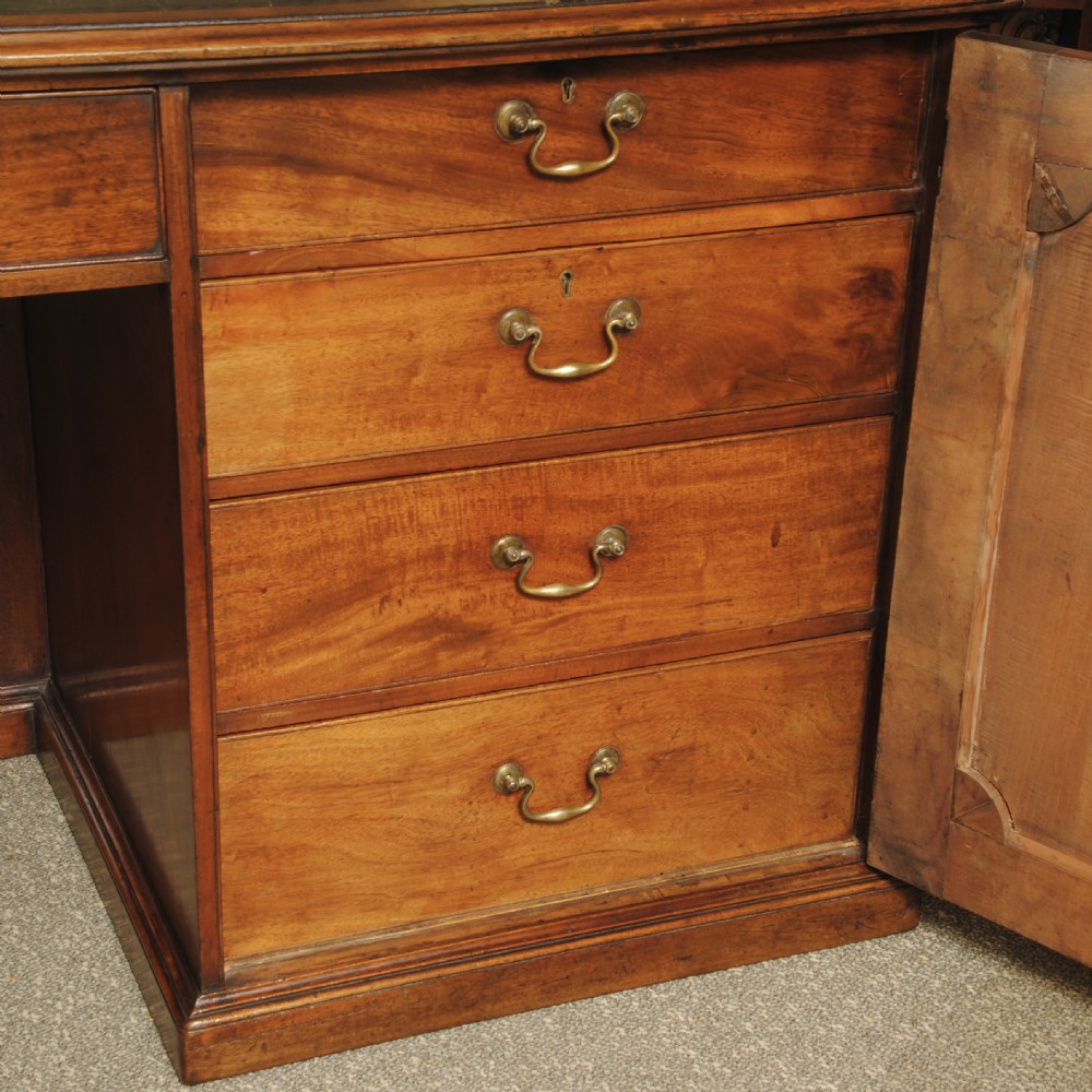 An antique mahogany partners desk featuring a black leather inset top, central frieze drawer, and pedestal cupboards with fielded panels. View II
