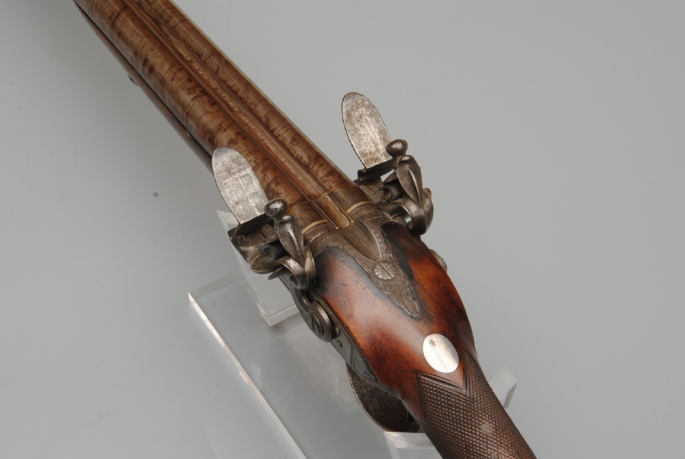 An antique double-barrel flintlock sporting gun featuring a dark walnut wood stock, twin steel barrels, and intricate lockwork. View IV