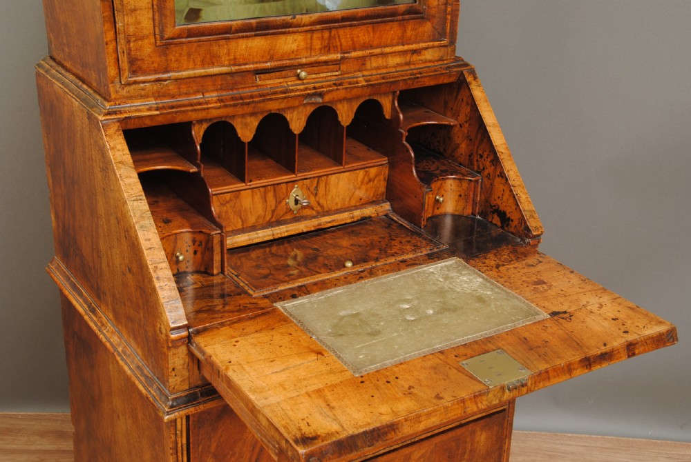 A compact Queen Anne walnut bureau bookcase featuring an arched mirror door upper section above a slant-front desk and two drawers on bun feet. View III