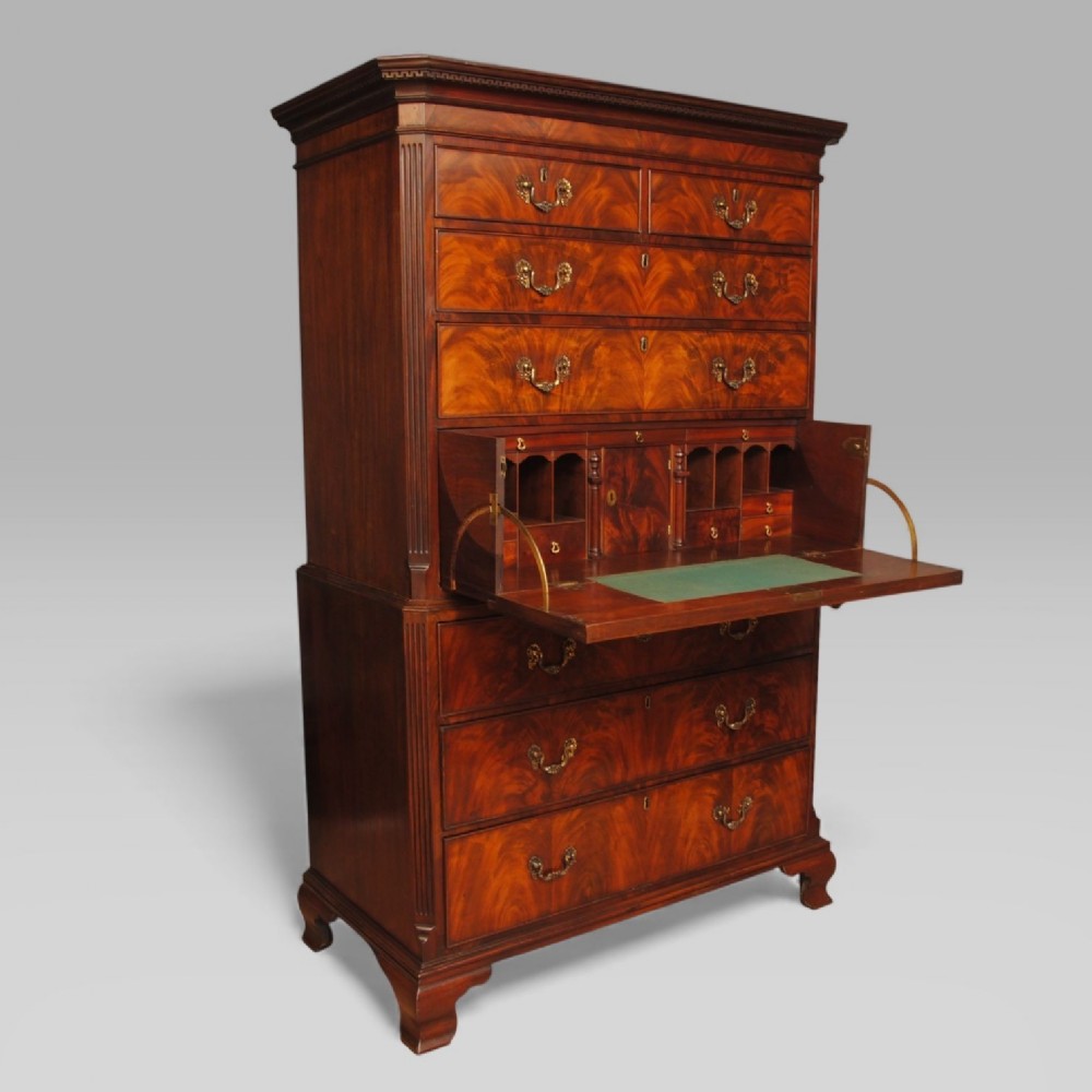 A Georgian Chippendale period flame mahogany secretaire tallboy featuring a two-part chest structure with a fall-front fitted writing drawer and ogee bracket feet.